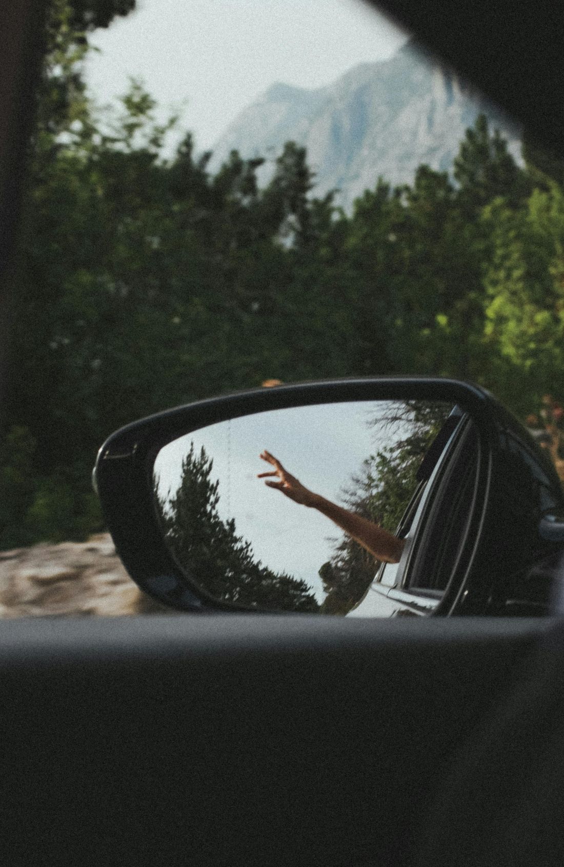 Waving arms out of window on a road trip