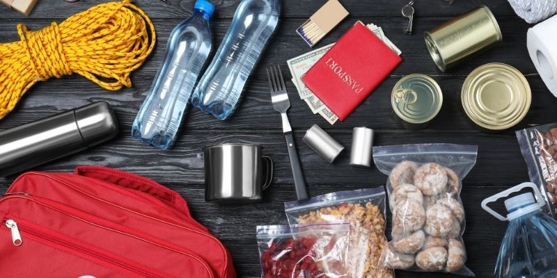 A red backpack filled with food, water, and various essential items.