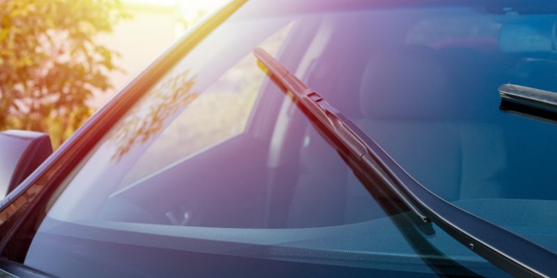 A car windshield wiper featuring a pair of sleek black blades is prominently displayed.