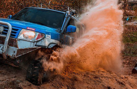 A 4x4 car in a dust cloud.