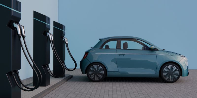 Blue car parked at electric charge point.