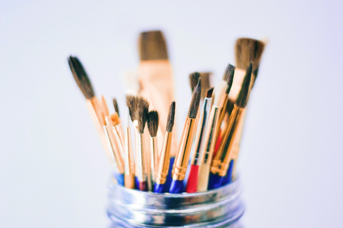 A jar filled with paint brushes