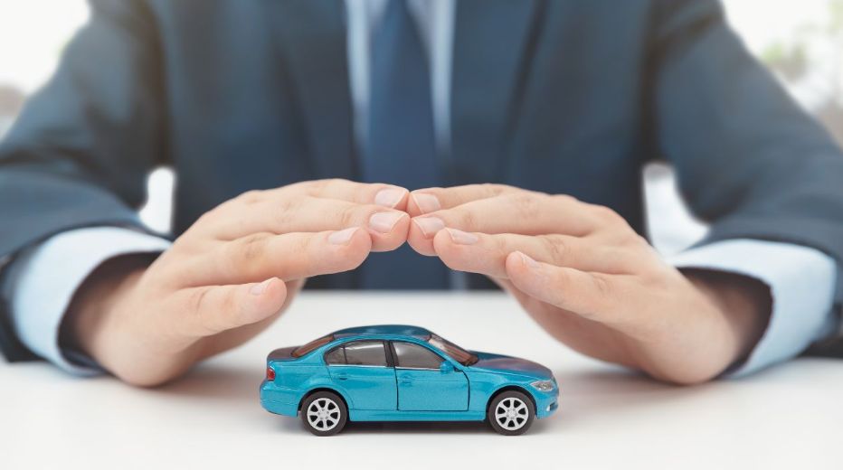 A Blue Toy Car Protected By a Mans Hands
