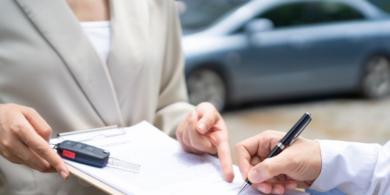 Person completing paperwork to obtain car keys.