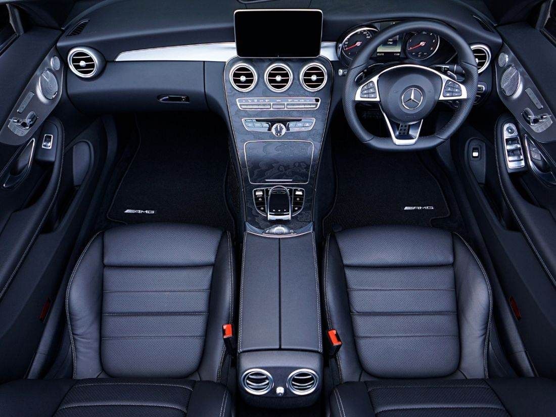 Birds eye view of a Mercedes-Benz interior, showing the front seat, steering wheel and dashboard