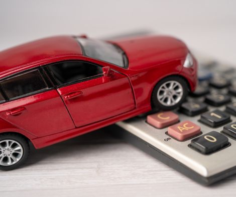 Red toy car on top of a calculator