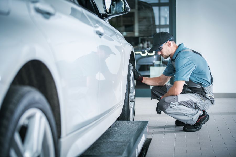 man looking at car tyre