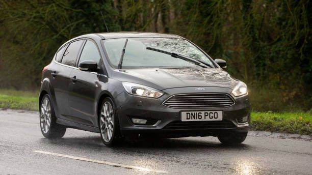 A grey Ford Focus in the rain