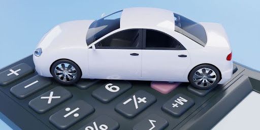 A white toy car sitting into of a calculator