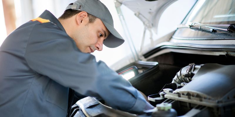 A Mechanic Under A Car Bonet