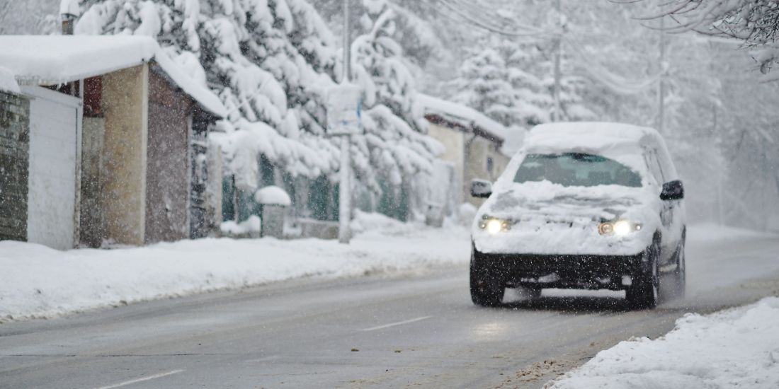 car covered in snow on road 