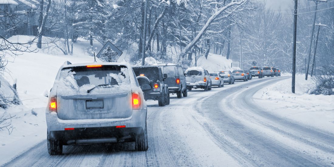 cars driving along snowy road 