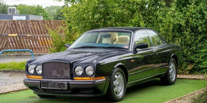 A Black Classic Car Parked up with Rain on