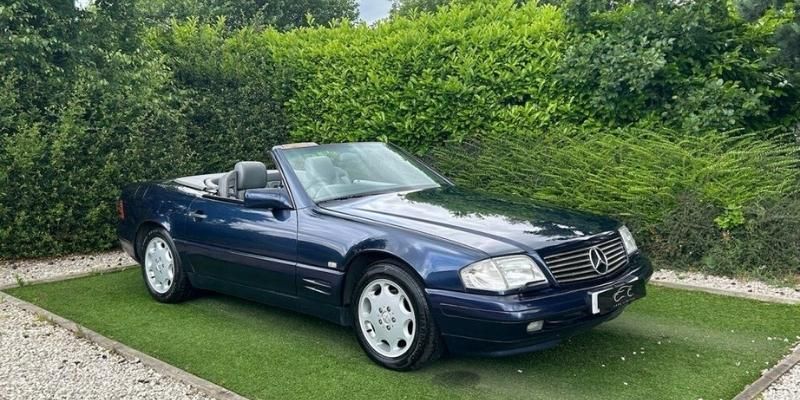 A Dark Blue Classic Car Photographed on Grass