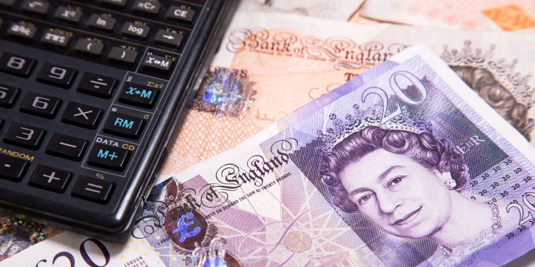 A calculator resting on a stack of money notes suggesting a successful car sale.