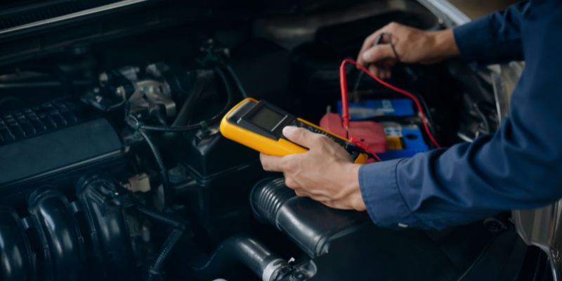 Mechanic conducting battery test on car.