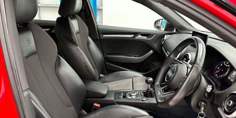 Interior view of a red car showcasing luxurious leather seats and a stylish dashboard design.