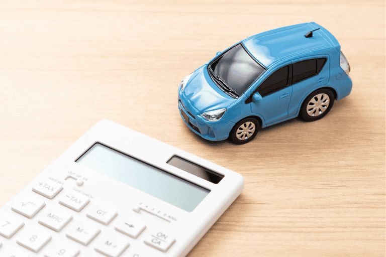 Blue toy car next to a calculator on a table