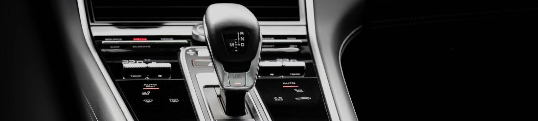 A photo showcasing a detailed view of a gearstick from the back seat of a car.