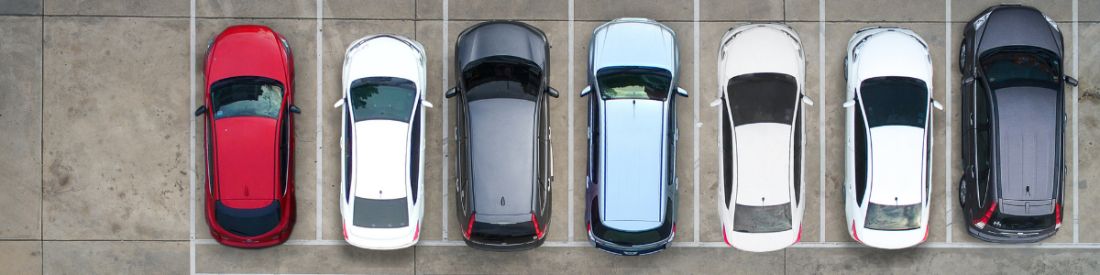 Birds eye view of cars parked in a uniform line