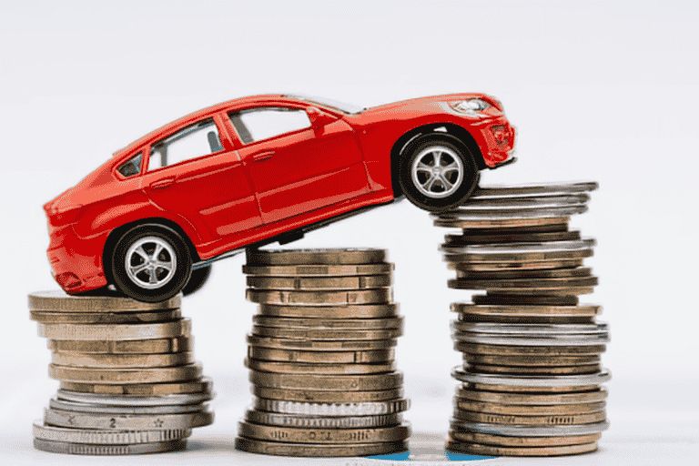 A red toy car climbing up a stack of silver and copper coins