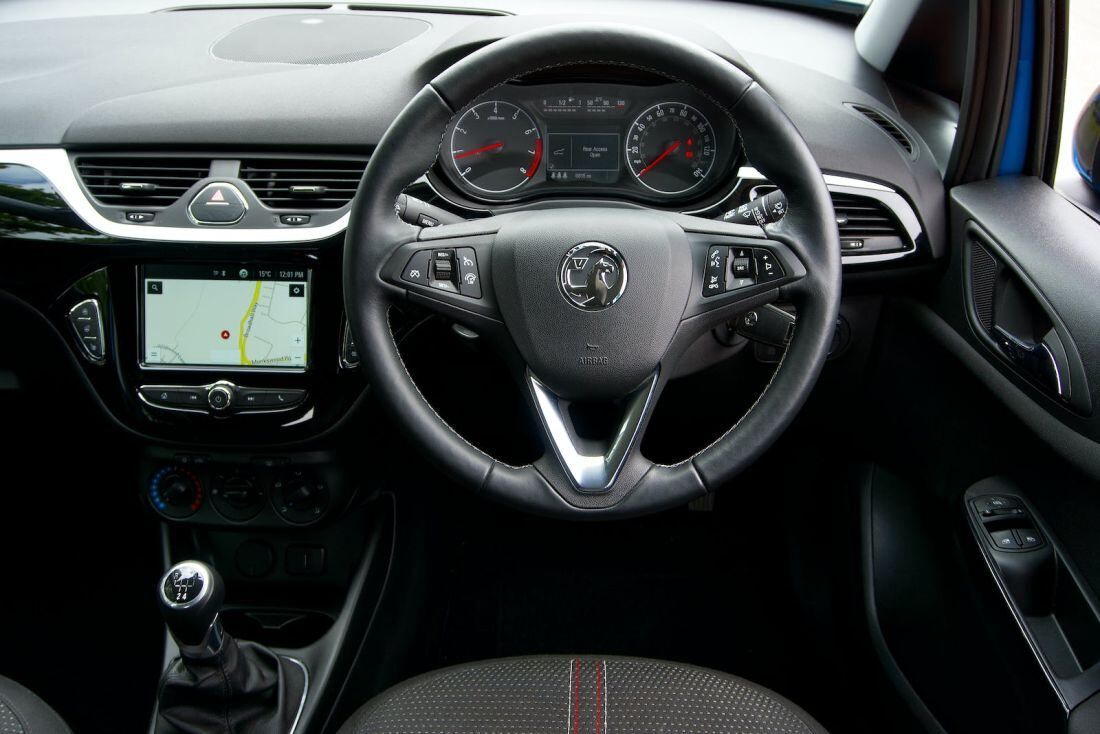 Interior view of a car showcasing the steering wheel and dashboard, highlighting the vehicle's design and controls.