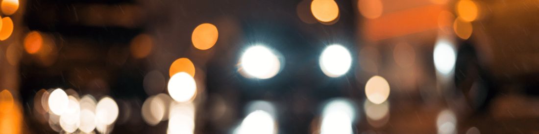 Out-of-focus car headlights and street lights at night.