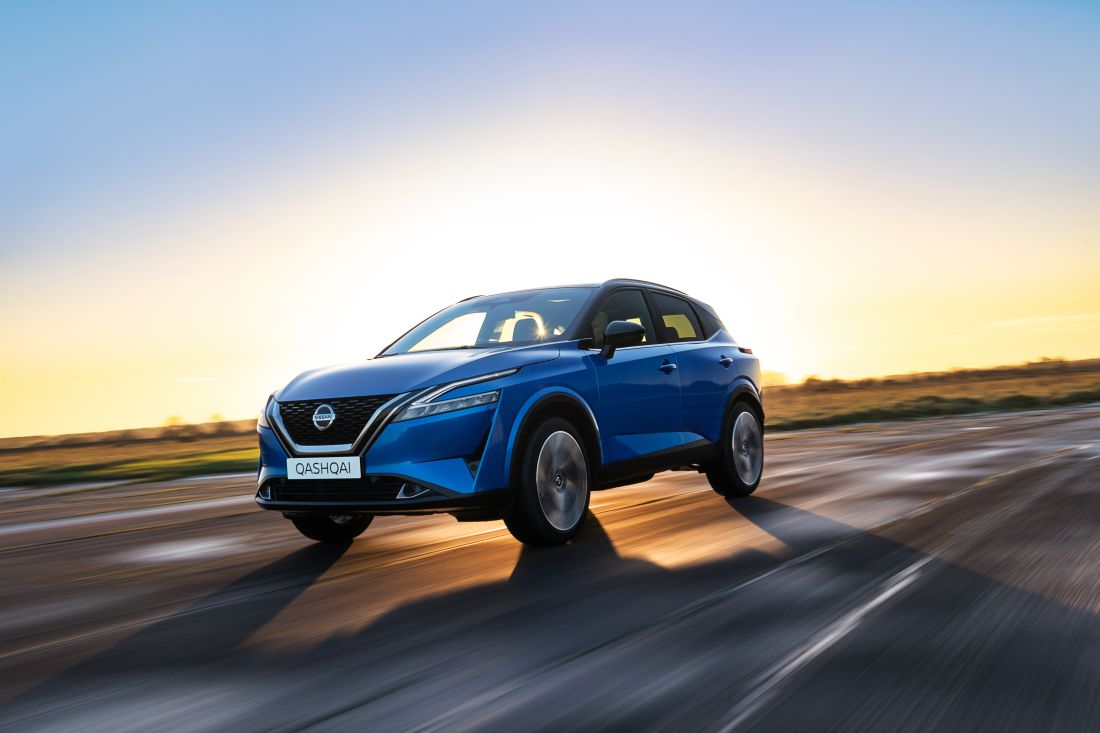 A Nissan Qashqai driving with a sunset in the background.