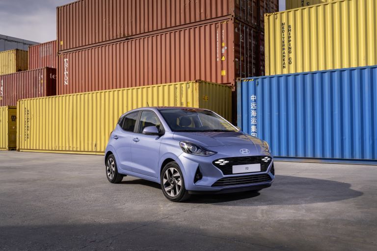 Hyundai i10 compact hatchback photographed in front of colourful shipping containers.