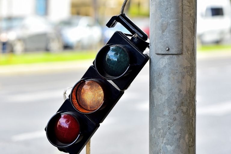 broken traffic light hanging off a lampost