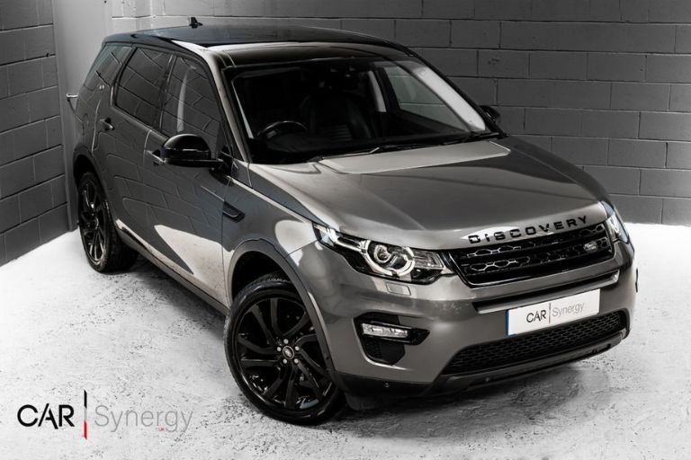 A grey Land Rover Discover Sport inside a car dealership.