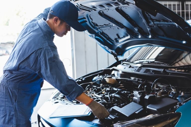 A car mechanic changing a timing belt.
