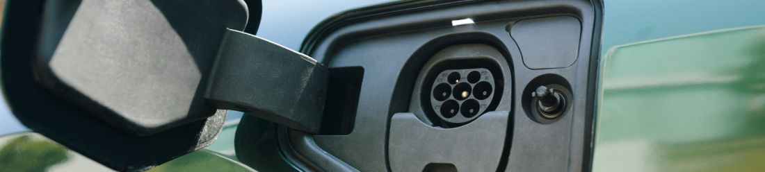 An electric vehicles open charging port hatch.