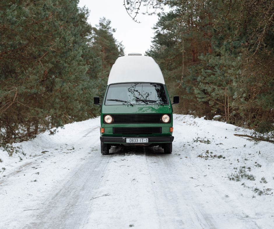 Green campervan in snow 