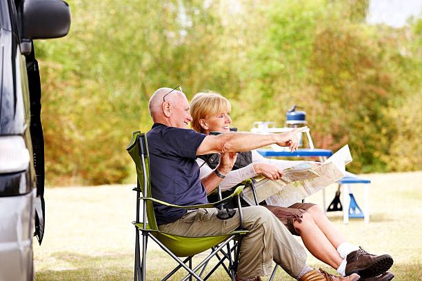 couple sat outside campervan on fold out furniture