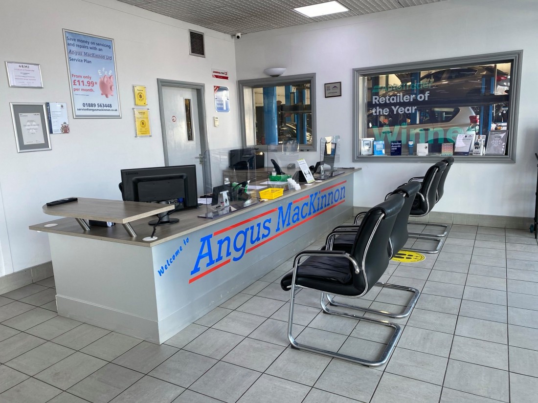 Angus MacKinnon's new reception desk with the brand name across it in bold lettering. Four chairs are placed in front of the desk.
