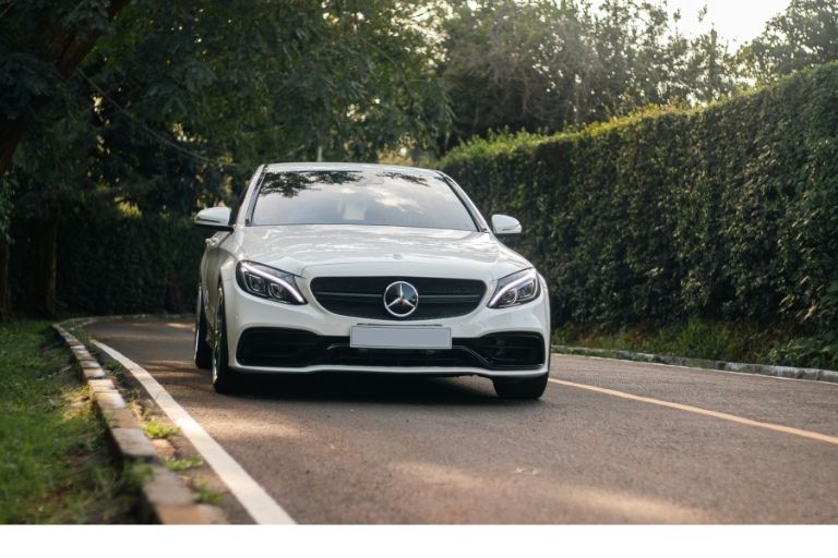 white mercedes c-class driving