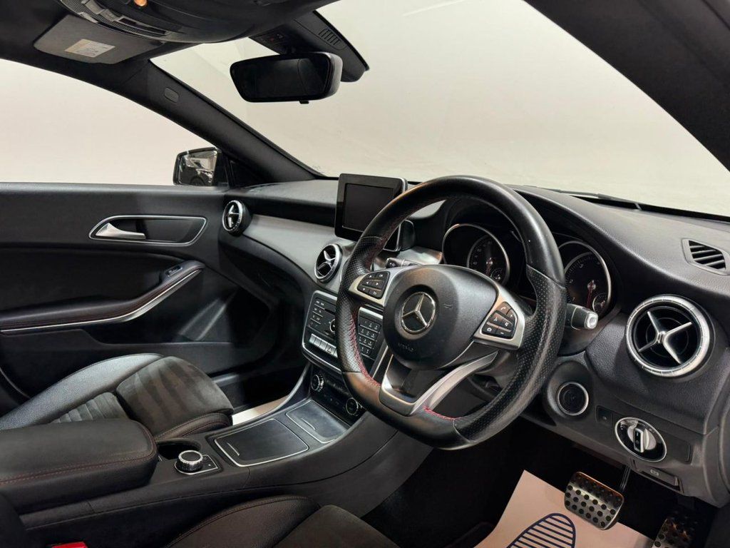 Interior view of a Mercedes car featuring luxurious leather seats and a sleek steering wheel.