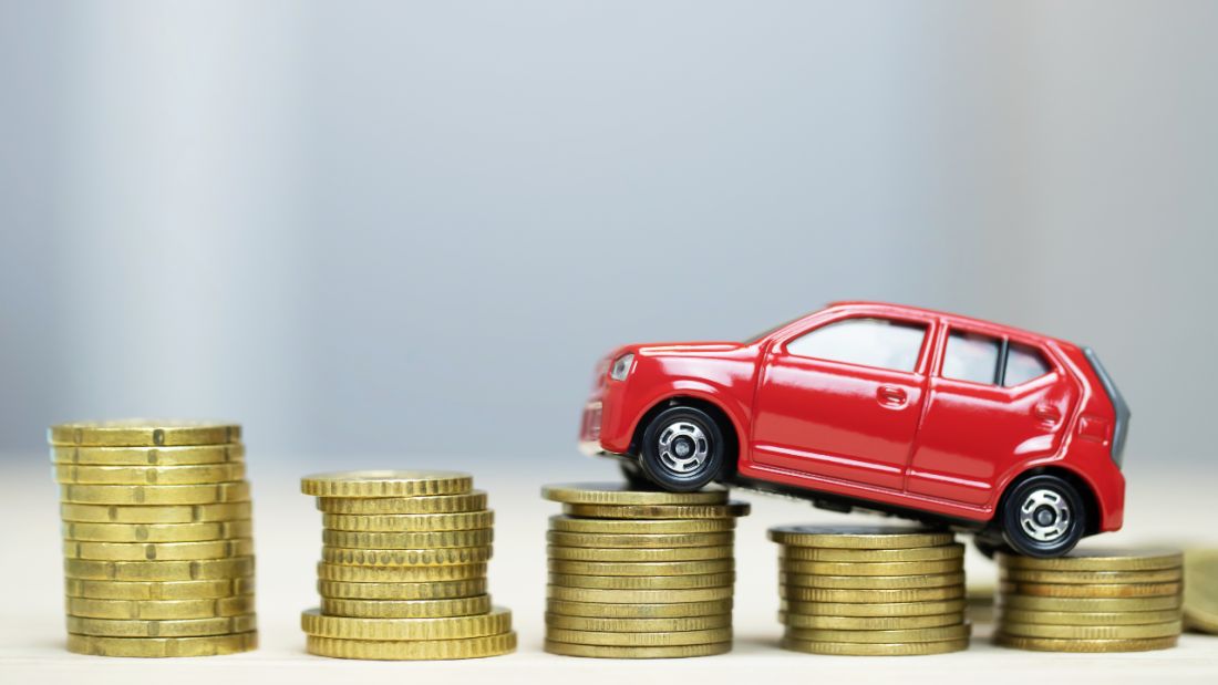 Toy car climbing stacks of coins