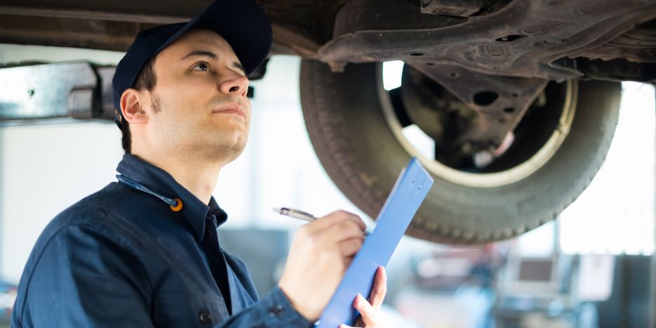MOT test being done on a used car by a man in a used car dealership