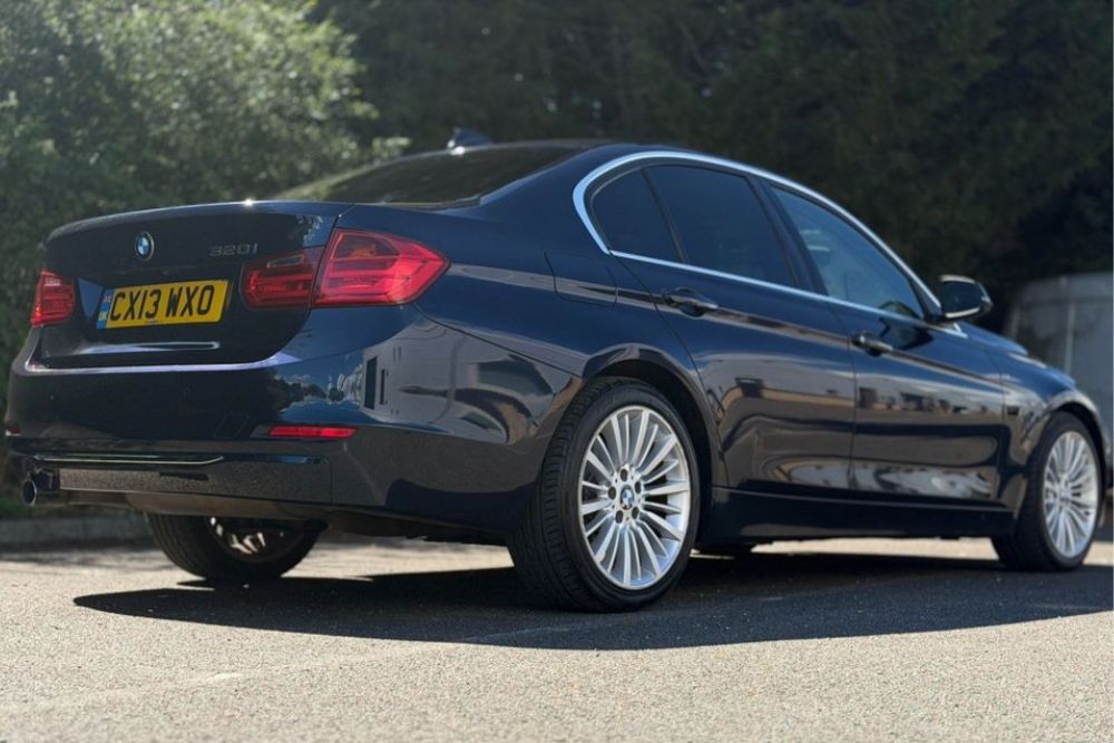 Dark blue BMW 320i Luxury petrol manual saloon parked at Mersea Cars dealership in Colchester Essex
