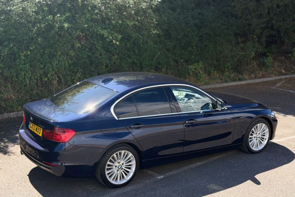 Dark blue BMW 320i Luxury petrol manual saloon parked at Mersea Cars dealership in Colchester Essex