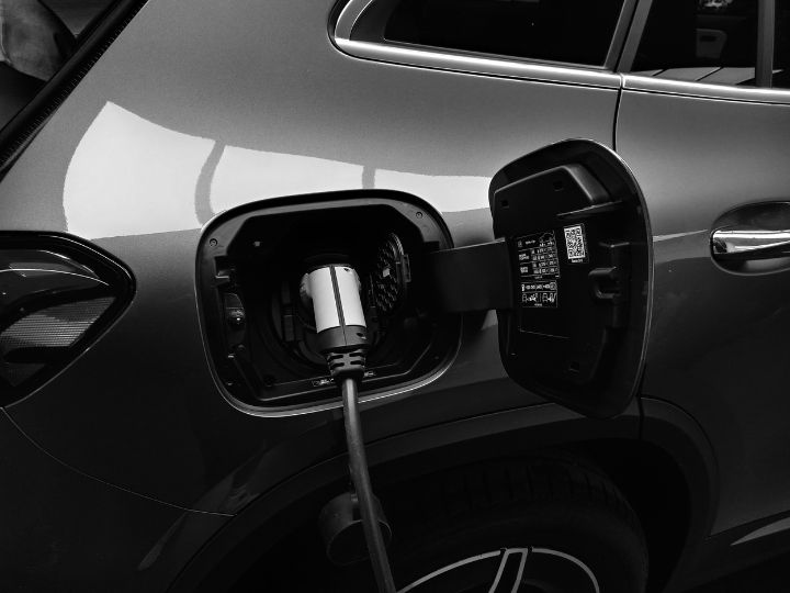 An electric vehicle connected to a charging station, indicating it is in the process of recharging its battery.