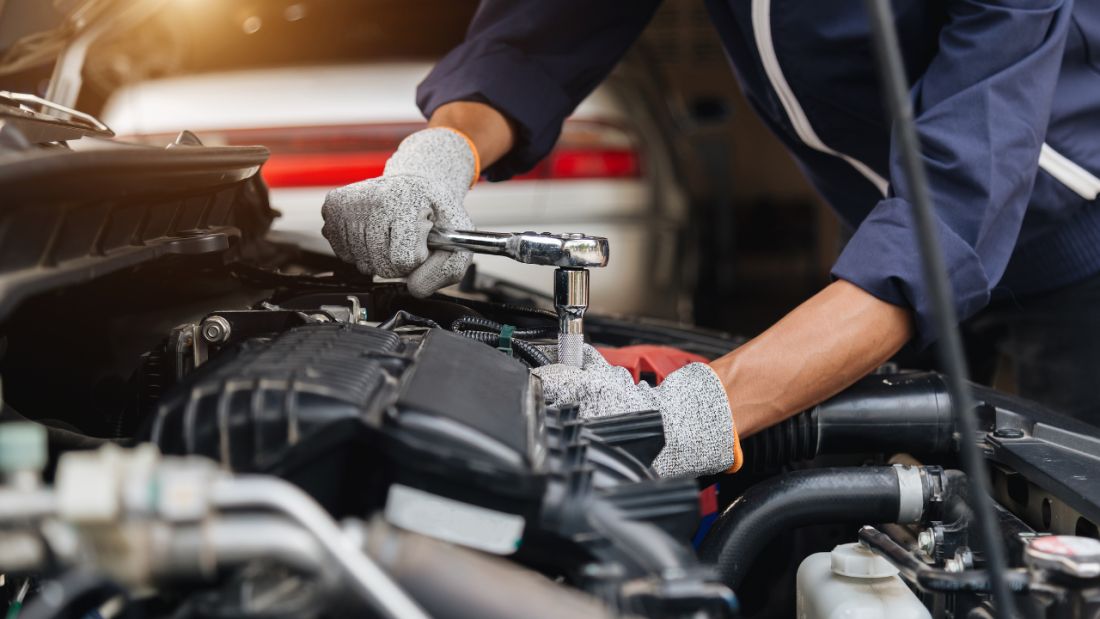 Underneath the bonnet of a car conducting services
