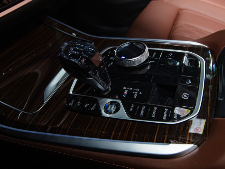 The interior of a luxury car featuring a sleek steering wheel and advanced control panel for an elegant driving experience.