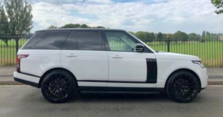 White Range Rover SUV side profile, parked outdoors.