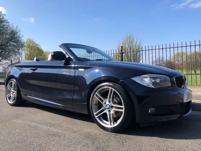 Black BMW convertible parked outdoors in sunny weather.