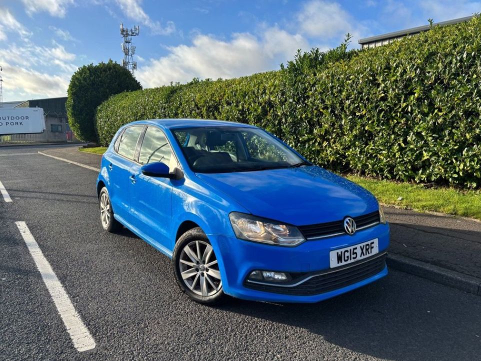A blue, used Volkswagen Polo outside on the road