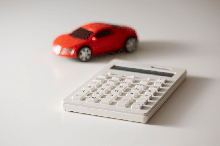 a red toy car next to a calculator