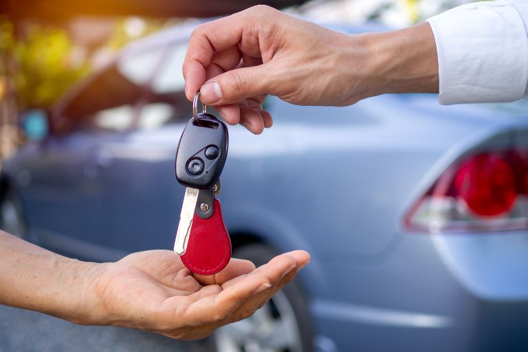 car keys being handed over, showing a used car sales deal